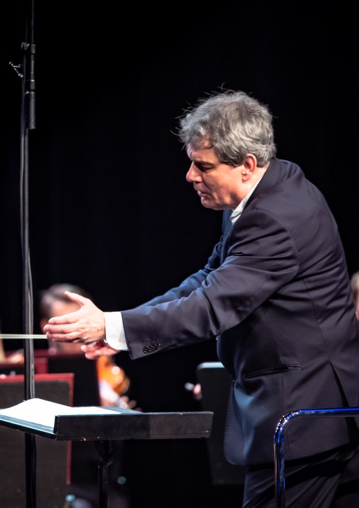 mężczyzna w garniturze z wyciągniętymi rękami w lewo