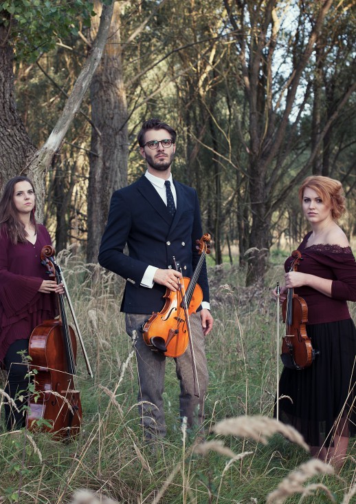 four people in the forest holding instruments