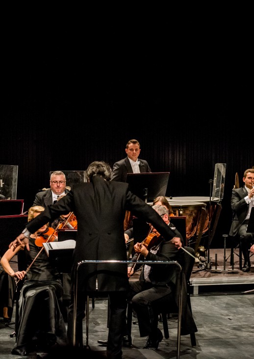 dyrygent stojący przed orkiestrą