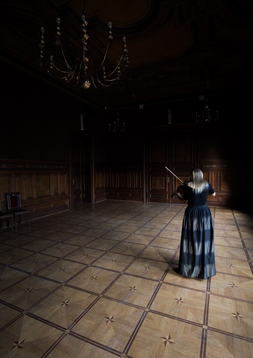 kobieta odwrócona tyłem gra na skrzypcach