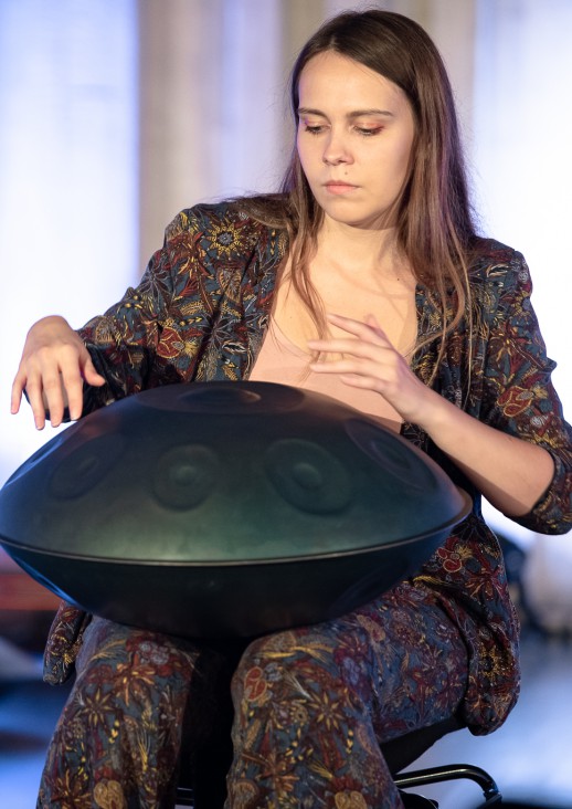 siedząca kobieta gra na instrumencie muzycznych handpan