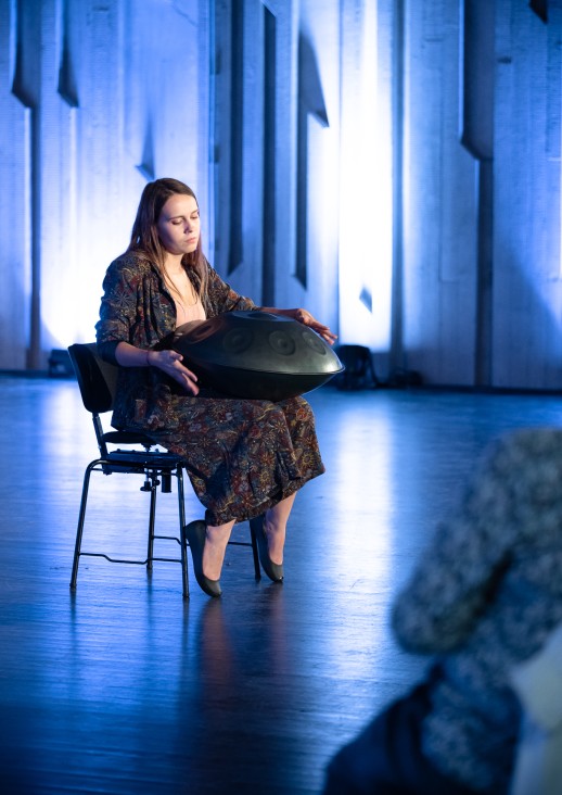 kobieta siedząca na krześle grająca na instrumencie perkusyjnym