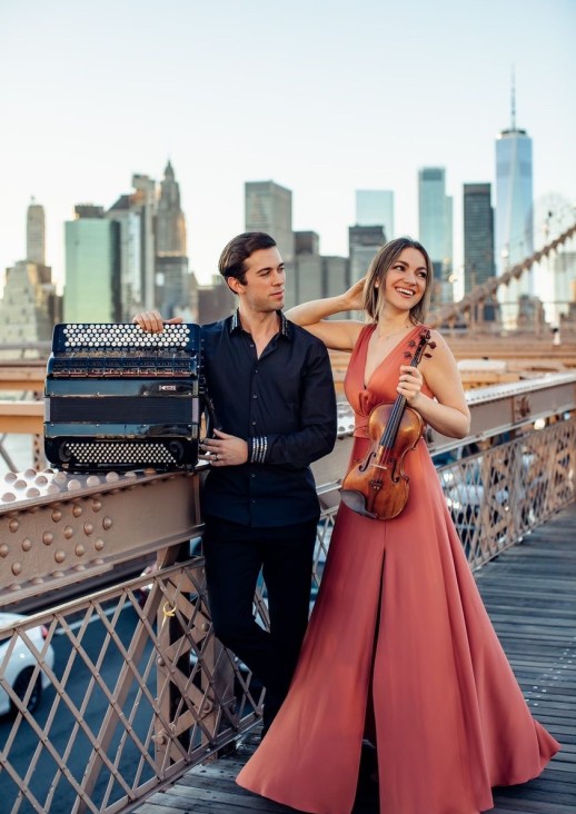 stojący mężczyzna z akordeonem i kobieta trzymająca skrzypce