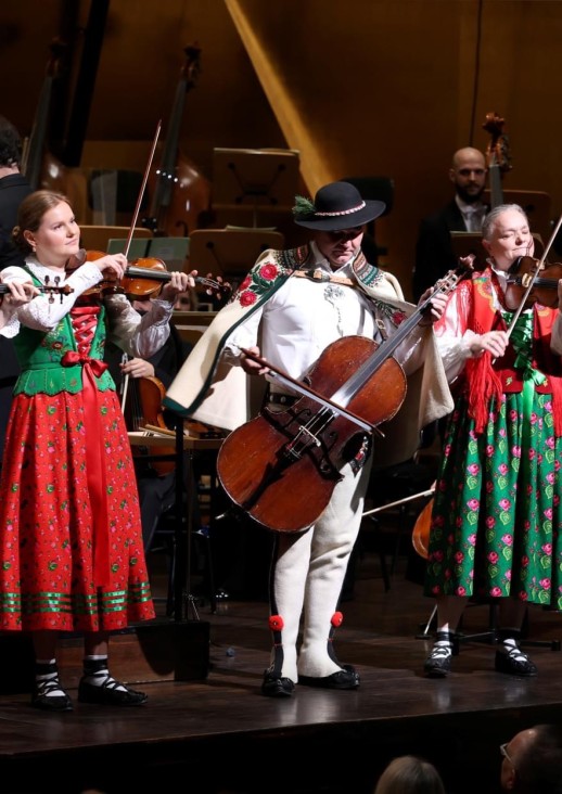 trzy kobiety i mężczyzna w strojach góralskich grają na instrumentach muzycznych