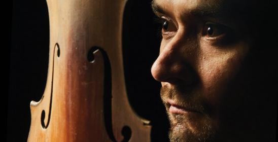 The man's face next to the soundboard of violins