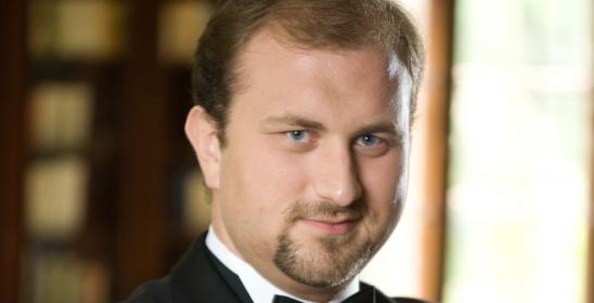 mężczyznaw ciemnej marynacre ze skrzyżowanymi rękoma na piersiach