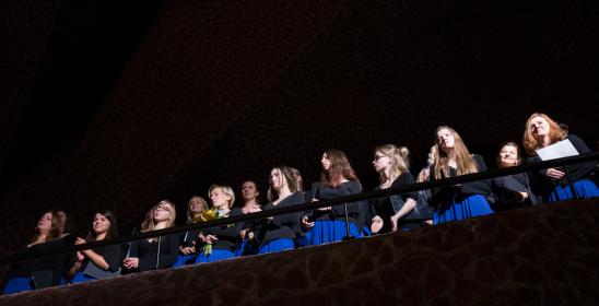 kobiety w czarnych bluzkach i i chabrowych spódnicach