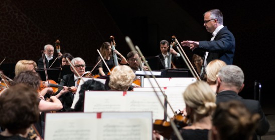 Musicians playing string instruments from notes placed on stands