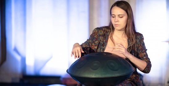 siedząca kobieta gra na instrumencie muzycznych handpan
