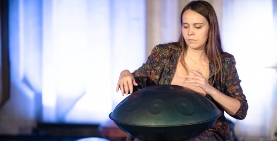 siedząca kobieta gra na instrumencie muzycznych handpan