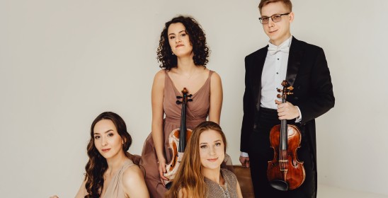 trzy kobiety i mężczyzna trzymają instrumenty smyczkowe