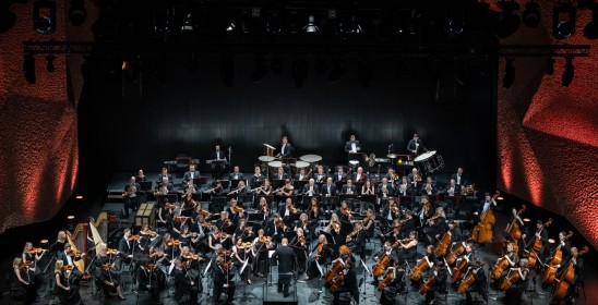 orkiestra symfoniczna siedzi na scenie
