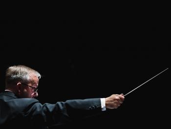 a man in a tailcoat with a baton