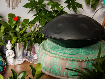 a handpan musical instrument lying on a pillow