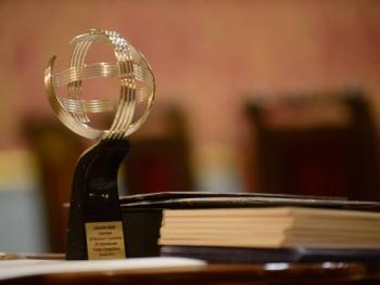 A silver astrolabe-shaped statuette for the laureate of the competition, standing on a table.