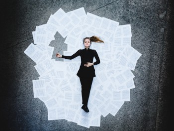 a woman lying on sheets of notes