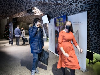 mężczyzna przemawiający przed koncertem, w tle siedząca orkiestra