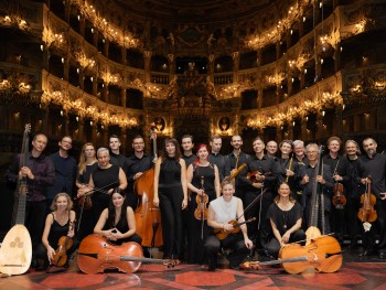 grupa osób trzymających instrumenty smyczkowe